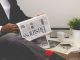 person sitting near table holding newspaper